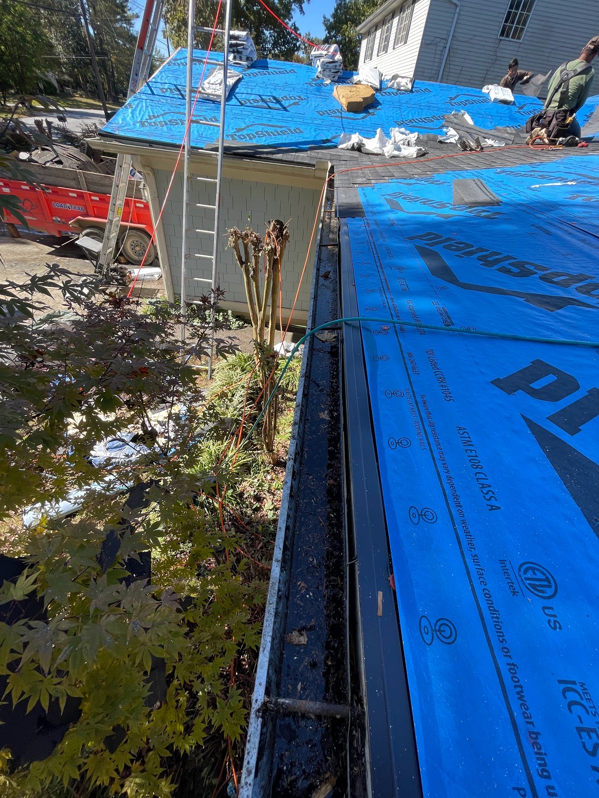 The Smart Company GA — seamless aluminum gutter install in progress with blue underlayment and fresh shingles above